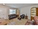 Cozy living room with beautiful floors, ample natural light, comfortable leather seating and wooden shelves at 1304 Burbank Ct, Sun City Center, FL 33573