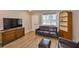 Comfortable living room featuring wooden floors, neutral walls, ample natural light and classic wooden furniture at 1304 Burbank Ct, Sun City Center, FL 33573
