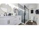 Bright bathroom features dual sinks, striking gold accents, and a glass enclosed shower at 1357 S Betty Ln, Clearwater, FL 33756
