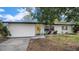Charming single-story home with a lush front lawn and bright yellow front door at 1357 S Betty Ln, Clearwater, FL 33756