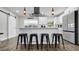 Modern kitchen boasts stainless appliances, sleek white cabinets, pendant lighting, and breakfast bar with seating at 1357 S Betty Ln, Clearwater, FL 33756
