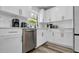 Well-lit kitchen with stainless steel dishwasher, white cabinets with gold hardware and modern faucet at 1357 S Betty Ln, Clearwater, FL 33756