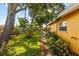 Backyard featuring lush greenery, mature trees, and a brick walkway at 1453 62Nd S Ter, St Petersburg, FL 33705