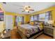 Comfortable bedroom featuring a ceiling fan, wood flooring and two large windows at 1453 62Nd S Ter, St Petersburg, FL 33705