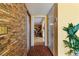 Hallway with a unique brick wall and mosaic tiled floor leading to the living room at 1453 62Nd S Ter, St Petersburg, FL 33705