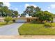 Charming single-story home featuring a well-manicured lawn, mature trees and a long driveway at 1453 62Nd S Ter, St Petersburg, FL 33705