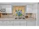 Modern kitchen boasting white cabinetry, ample counter space, and a stainless steel sink at 1453 62Nd S Ter, St Petersburg, FL 33705