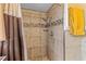 Bright shower featuring tile surround, updated shower head, and glass doors at 1453 62Nd S Ter, St Petersburg, FL 33705