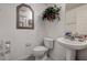 View of a powder room featuring white fixtures, a pedestal sink, and a floral accent at 14985 Alan Ct, Largo, FL 33771