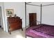 Traditional bedroom featuring dark wood furniture and a four-poster bed frame with purple linens at 14985 Alan Ct, Largo, FL 33771