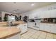 Bright kitchen with white cabinets and tile flooring, open to the living area at 14985 Alan Ct, Largo, FL 33771