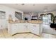 Open kitchen with white cabinets and dishwasher, flowing into the living room at 14985 Alan Ct, Largo, FL 33771