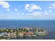 An aerial view showcases the waterfront property with beautiful surroundings and access to the open water at 150 Carlyle Dr, Palm Harbor, FL 34683