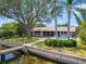 Scenic backyard view featuring a wooden dock and refreshing swimming pool at 150 Carlyle Dr, Palm Harbor, FL 34683