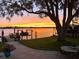 Waterfront property with a backyard featuring a dock, boat lift, and sunset views at 150 Carlyle Dr, Palm Harbor, FL 34683