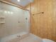 This bathroom features a glass enclosed shower, patterned wallpaper, and tile flooring at 150 Carlyle Dr, Palm Harbor, FL 34683