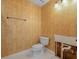 This bathroom is fitted with a toilet, patterned wallpaper, tile flooring, and towel bar at 150 Carlyle Dr, Palm Harbor, FL 34683