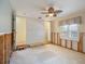 This bedroom features a ceiling fan, window with blind, doorway to bathroom and walk in closet at 150 Carlyle Dr, Palm Harbor, FL 34683