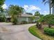 Charming one-story home with lush landscaping and a curved driveway, exuding curb appeal at 150 Carlyle Dr, Palm Harbor, FL 34683