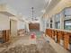 Open living area with large windows, chandelier, and exposed wall structure, waiting for remodeling at 150 Carlyle Dr, Palm Harbor, FL 34683