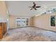 Bright living room featuring large windows, ceiling fan, and neutral paint, awaiting new flooring at 150 Carlyle Dr, Palm Harbor, FL 34683