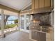 Outdoor kitchen with a stainless steel grill under a vent hood is set on a lanai with waterfront views at 150 Carlyle Dr, Palm Harbor, FL 34683