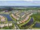 Stunning aerial view of a lakefront neighborhood, showcasing lush green landscaping and beautiful blue lakes at 16101 Cape Coral Dr, Wimauma, FL 33598