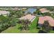 Lovely lakefront home featuring an extended screened-in lanai with mature palm trees and green landscaping at 16101 Cape Coral Dr, Wimauma, FL 33598