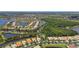 Aerial view of the homes in the community with mature trees, lush greenery, and a peaceful lake at 16101 Cape Coral Dr, Wimauma, FL 33598