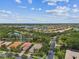 Wide aerial shot showcasing the lakefront community with lush landscaping, mature trees, and cloudy skies at 16101 Cape Coral Dr, Wimauma, FL 33598