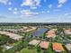 Picturesque aerial view of the beautiful community with lakes, landscaping and cloudy blue skies at 16101 Cape Coral Dr, Wimauma, FL 33598