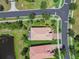 Aerial view of a home with a tile roof, screened-in patio, and landscaped yard near a pond at 16101 Cape Coral Dr, Wimauma, FL 33598