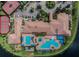 Overhead view of community clubhouse featuring pools, ample seating, well-maintained tennis courts, and lush surrounding greenery at 16101 Cape Coral Dr, Wimauma, FL 33598