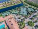 Beautiful aerial of the community with a lake, pool, tennis courts, clubhouse, and lush landscaping at 16101 Cape Coral Dr, Wimauma, FL 33598