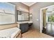 Bathroom featuring a tub with tile surround, granite countertop vanity, and view to the bedroom area at 16101 Cape Coral Dr, Wimauma, FL 33598