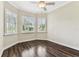Bright bedroom featuring wood floors, plantation shutters, a ceiling fan, and corner windows offering ample natural light at 16101 Cape Coral Dr, Wimauma, FL 33598