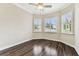 Bedroom featuring wood floors, plantation shutters, a ceiling fan, and corner windows offering ample natural light at 16101 Cape Coral Dr, Wimauma, FL 33598