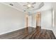 Open bedroom featuring wood floors, tray ceilings, and bright, natural lighting at 16101 Cape Coral Dr, Wimauma, FL 33598