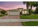 Inviting single Gathering home featuring a brick driveway, attached garage, and beautifully landscaped front yard at 16101 Cape Coral Dr, Wimauma, FL 33598