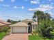 Well-maintained home with a tile roof, brick driveway, and lush tropical landscaping at 16101 Cape Coral Dr, Wimauma, FL 33598
