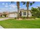 Beautiful single Gathering home with a lush lawn and elegant landscaping including a palm tree at 16101 Cape Coral Dr, Wimauma, FL 33598