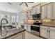 Well-equipped kitchen with stainless steel appliances, granite counters, and natural lighting at 16101 Cape Coral Dr, Wimauma, FL 33598