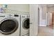 Well-equipped laundry room featuring modern washer and dryer with convenient overhead shelving at 16101 Cape Coral Dr, Wimauma, FL 33598