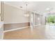 Open living room with tile flooring, crown molding, and sliding glass doors offering a bright and airy space at 16101 Cape Coral Dr, Wimauma, FL 33598
