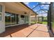 Large screened-in patio with brick flooring, ceiling fan, and sliding glass doors to the interior at 16101 Cape Coral Dr, Wimauma, FL 33598