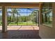 The screened in patio features a red brick floor, lush landscaping and green grass outside at 16101 Cape Coral Dr, Wimauma, FL 33598