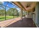 The screened in patio features brick floors and a view of the lush landscaping and blue sky at 16101 Cape Coral Dr, Wimauma, FL 33598