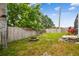 Fenced backyard with mature trees and a fire pit at 1758 Biarritz Cir, Tarpon Springs, FL 34689