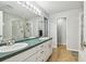 Bright bathroom featuring a double vanity, large mirror, shower and bath at 1758 Biarritz Cir, Tarpon Springs, FL 34689