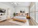Staged bedroom features natural light from shuttered windows, soft carpet and neutral decor at 1758 Biarritz Cir, Tarpon Springs, FL 34689